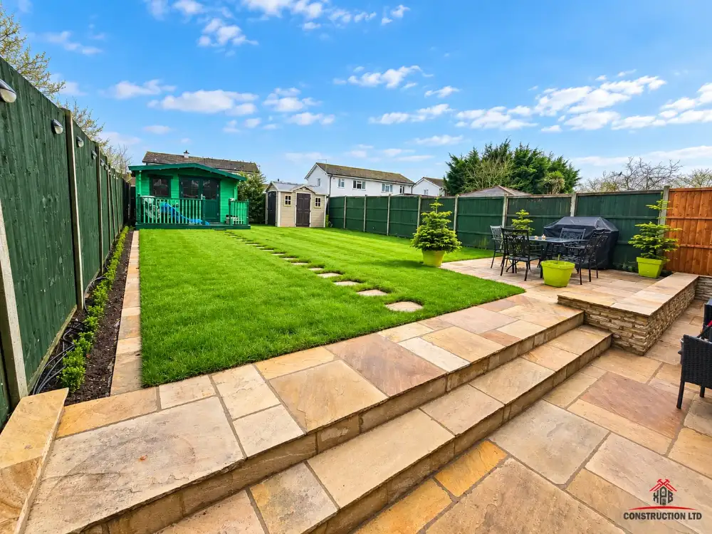 New sandstone patio, steps and lawn behind a semi-detached house